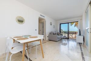 a white dining room with a white table and chairs at Ribera Beach in Los Alcázares