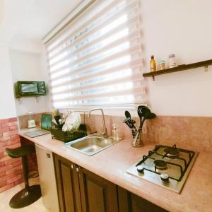 a kitchen with a sink and a stove and a window at Nortram Homes - Adenta in Apenkwa +36 photos