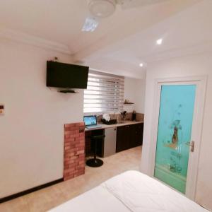 a bedroom with a desk and a television on a wall at Nortram Homes - Adenta in Apenkwa