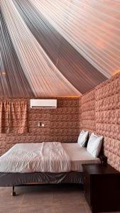 a bedroom with a bed in a brick wall at Pearl of the desert camp in Wadi Rum