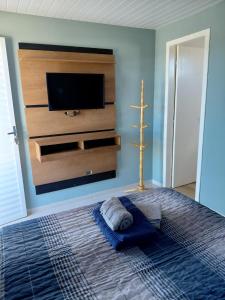 a bedroom with a flat screen tv on a wall at Pousada Por do Sol in Lapa