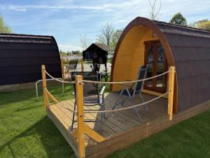 eine Holzterrasse mit einem Pavillon im Gras in der Unterkunft Campingplatz StroamCamp in Schwedt