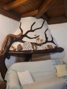 a wooden shelf with a tree on the wall at Agriturismo nuraghe Putzu Canu in Perfugas
