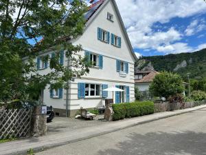 a white house with blue windows and an umbrella at ZwergDackelAdlerHirsch in Beuron