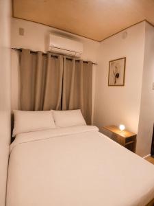 a bedroom with a white bed and a window at GASA Guesthouse in Compostela +22 photos