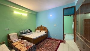 a room with a bed and a chair and a table at The Raulane Homestay in Kalpa