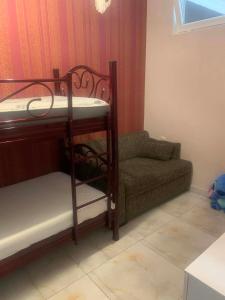 a small room with a bunk bed and a couch at Memed abashidzis 16 in Kobuleti
