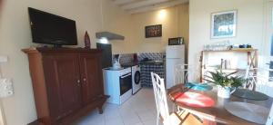 a kitchen with a dining room table and a television at Le gîte du château in Monget +32 photos