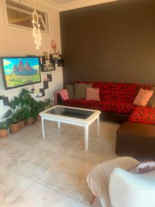a living room with a red couch and a coffee table at Memed abashidzis 16 in Kobuleti