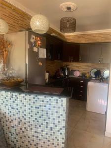 a kitchen with a refrigerator and a tile counter top at Memed abashidzis 16 in Kobuleti