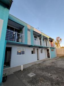 a blue and white building with a parking lot at Pousada Por do Sol in Lapa