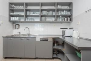 a kitchen with white cabinets and a sink at Villa Victoris Beachfront Luxury Villa with Heated Spa Pool Podstrana in Podstrana +44 photos