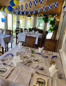 a dining room with a table with a white table cloth at Hotell Tussilago i Essunga in Nossebro
