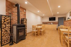 a living room with a fireplace and a table and chairs at Penzion Kopaninky in Bítov