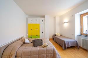 a bedroom with two beds and a yellow wall at Casa Olimpo in Agerola +39 photos