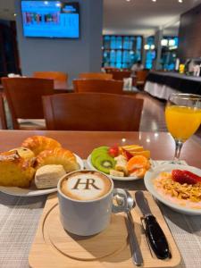 a table with plates of food and a cup of coffee at Hotel República in Villa María