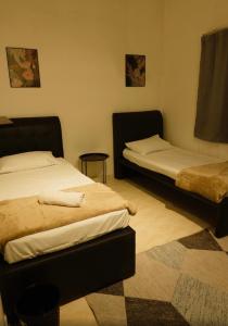 a bedroom with two beds and a rug at Yasmeen pool cottage in Temerloh +1 photo