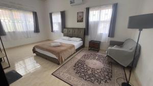 a bedroom with a bed and a chair at Yasmeen pool cottage in Temerloh