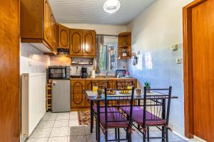 a kitchen with a table and chairs and a kitchen with a refrigerator at 4 seasons home Ofrinio in Ofrínion