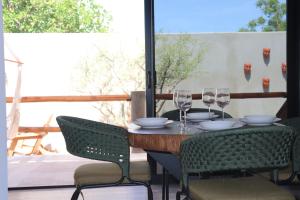 a table with wine glasses and chairs on a patio at Las 3 Carabelas BCS in El Sargento