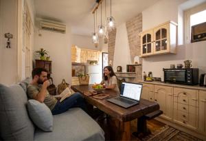 a man and a woman sitting at a table with a laptop at Apeiron Acropolis Suites by HC in Athens