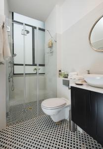 een badkamer met een douche, een toilet en een wastafel bij Reines5 TLV in Tel Aviv