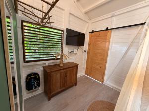 a bathroom with a wooden door and a window at Bungalow la tipik in Saint-François