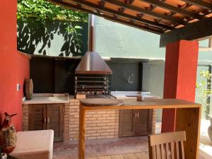 eine Außenküche mit Grill und Tisch in der Unterkunft Casa do Ventoo in Búzios