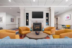 a living room with a couch and a fireplace at Garner Hotel Brockton - Boston by IHG in Brockton