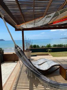 eine Hängematte auf einer Terrasse mit Blick auf das Meer in der Unterkunft Casa do Ventoo in Búzios
