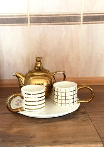a tea kettle and two cups on a plate at Prizma in Cetinje