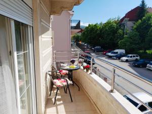 a balcony with a table and chairs and a street at Prizma in Cetinje
