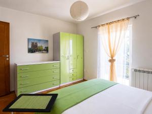 a bedroom with a green bed and a window at Prizma in Cetinje