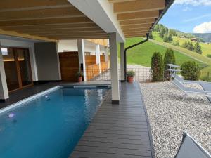 a swimming pool in a yard with a house at Hotel Elisabeth Panorama in Antermoia