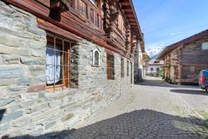 a stone building with a window on a street at Lueur de la Rouja in Champoluc