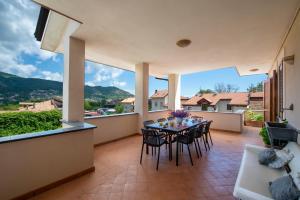 a patio with a table and chairs on a balcony at Casa Olimpo in Agerola