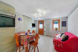 a living room with a table and a red couch at Lueur de la Rouja in Champoluc
