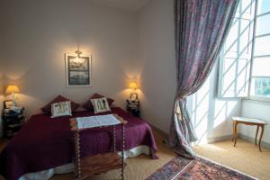 a bedroom with a bed and a large window at Chateau de Durtal in Durtal