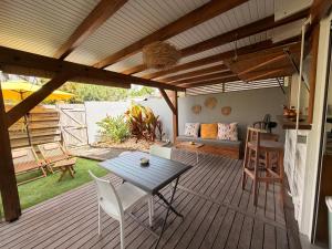 a patio with a table and chairs on a deck at Bungalow la tipik in Saint-François