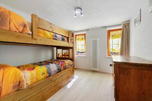 a bedroom with two bunk beds and a desk at Lueur de la Rouja in Champoluc