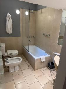 a bathroom with a tub and a toilet and a sink at Hotel República in Villa María +10 photos