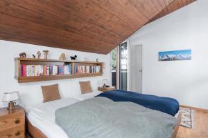 a bedroom with a bed with a wooden ceiling at Charming Alpine Apt with View 5min to Interlaken Ost in Interlaken