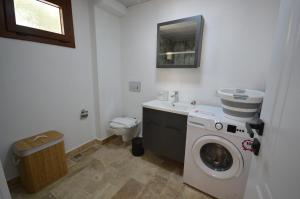a bathroom with a washing machine and a toilet at Villa Nature in Kırıkyayla