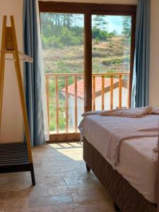 a bedroom with a bed and a view of a balcony at Villa Nature in Kırıkyayla +19 photos