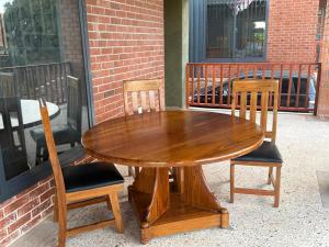 a wooden table and two chairs sitting next to a building at Buye Holiday House in Mwanza