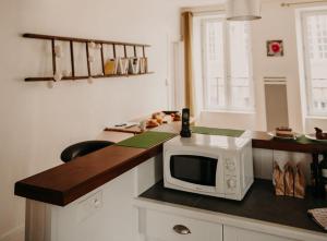a kitchen with a microwave on a counter at Le Classique in Saint-Sulpice-le-Guérétois +18 photos
