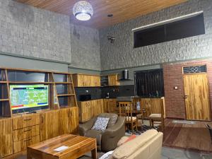 a living room with a couch and a tv at Buye Holiday House in Mwanza