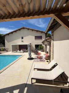 a patio with a swimming pool and a house at Le Vieux Platane in Malissard