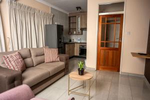 a living room with a couch and a table at Sycamon Suites in Jwaneng +18 photos