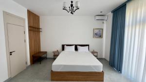a bedroom with a bed and a chandelier at Humor Hotel in Tashkent